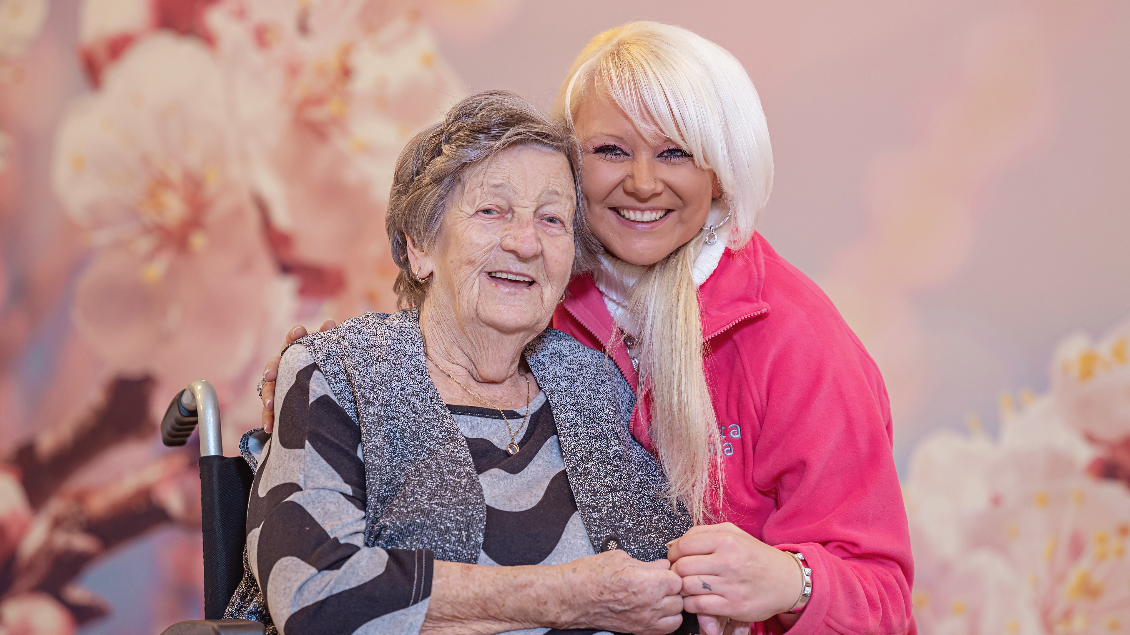 Mitarbeiterin der LaVitaCura Pflegedienst GmbH umarmt ältere Dame im Rollstuhl ©LaVitaCura Pflegedienst GmbH